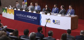 Audiência pública no plenário do TSE. No palco, há uma mesa longa com o ministro Nunes Marques e...