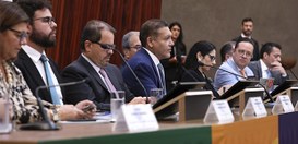 A imagem registra uma audiência pública no Tribunal Superior Eleitoral (TSE). No centro da mesa,...